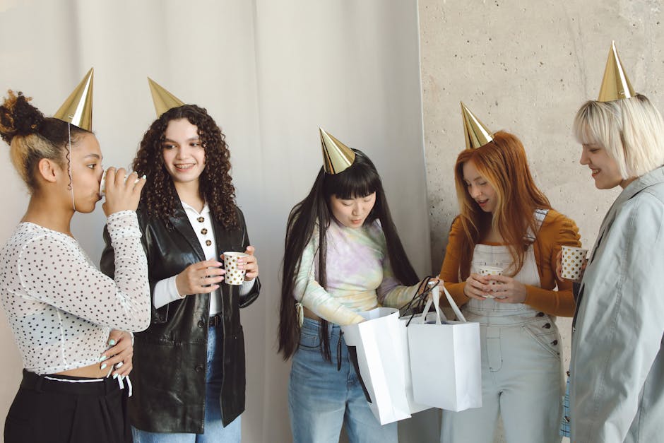Five young women celebrating with party hats and gifts indoors.