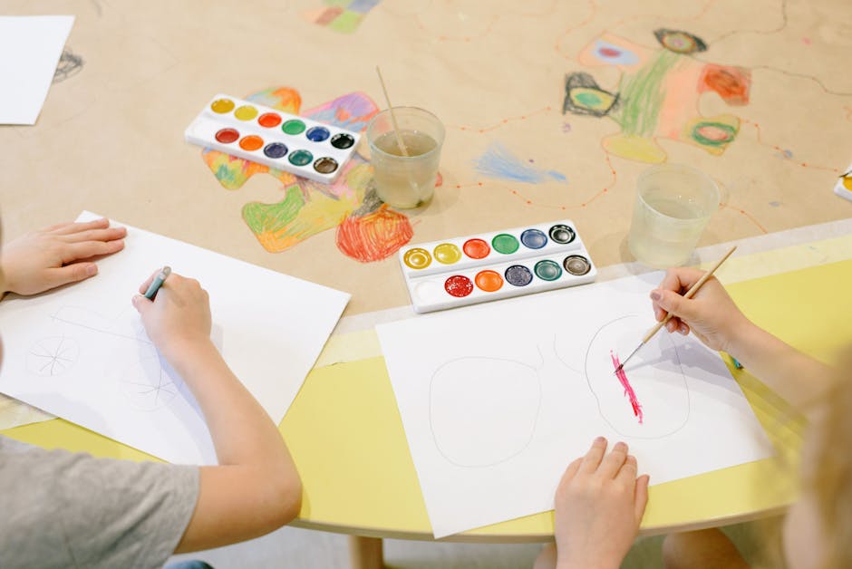 Two children painting with watercolors, enjoying a creative activity.